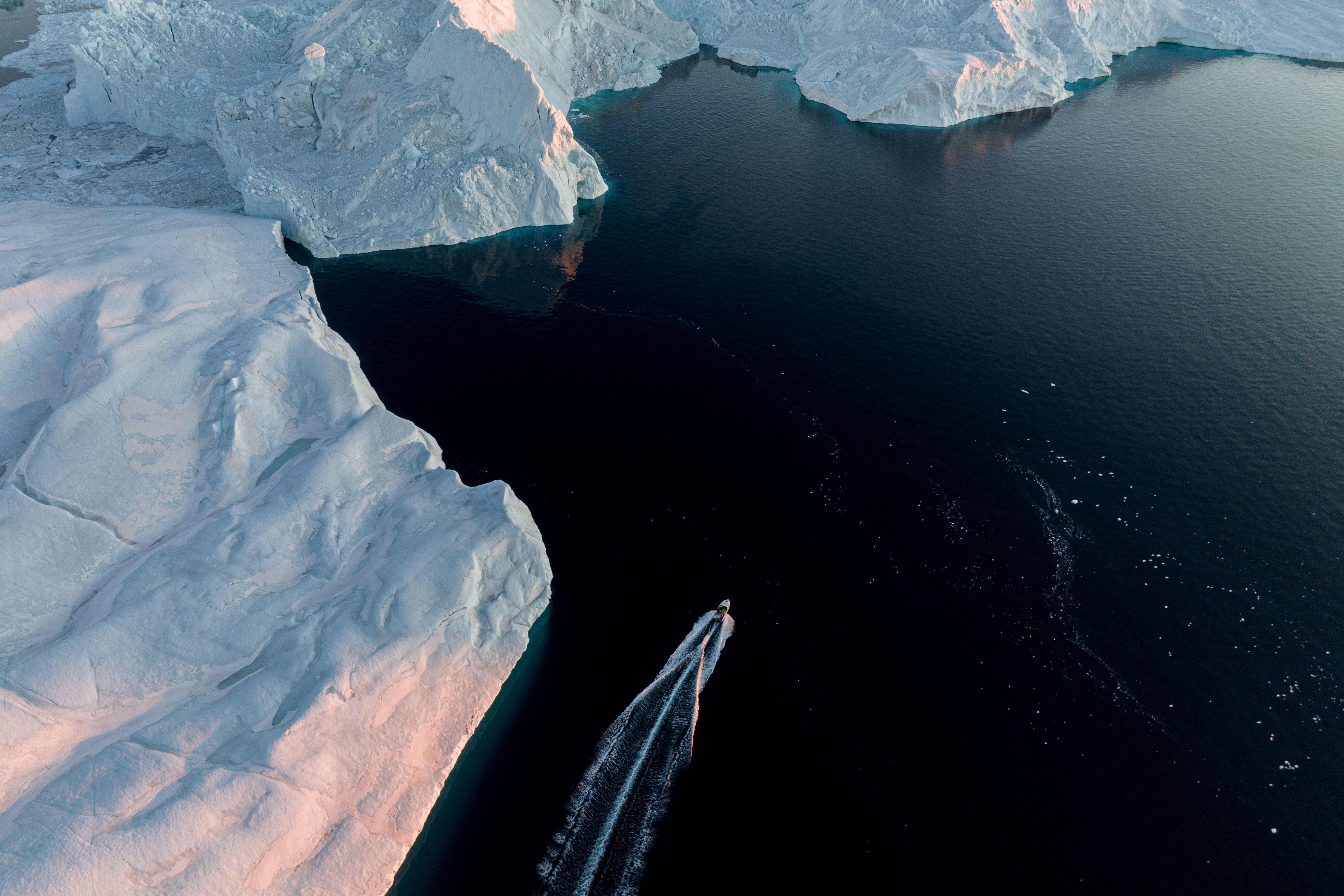Un barco pesquero navega frente a un iceberg...