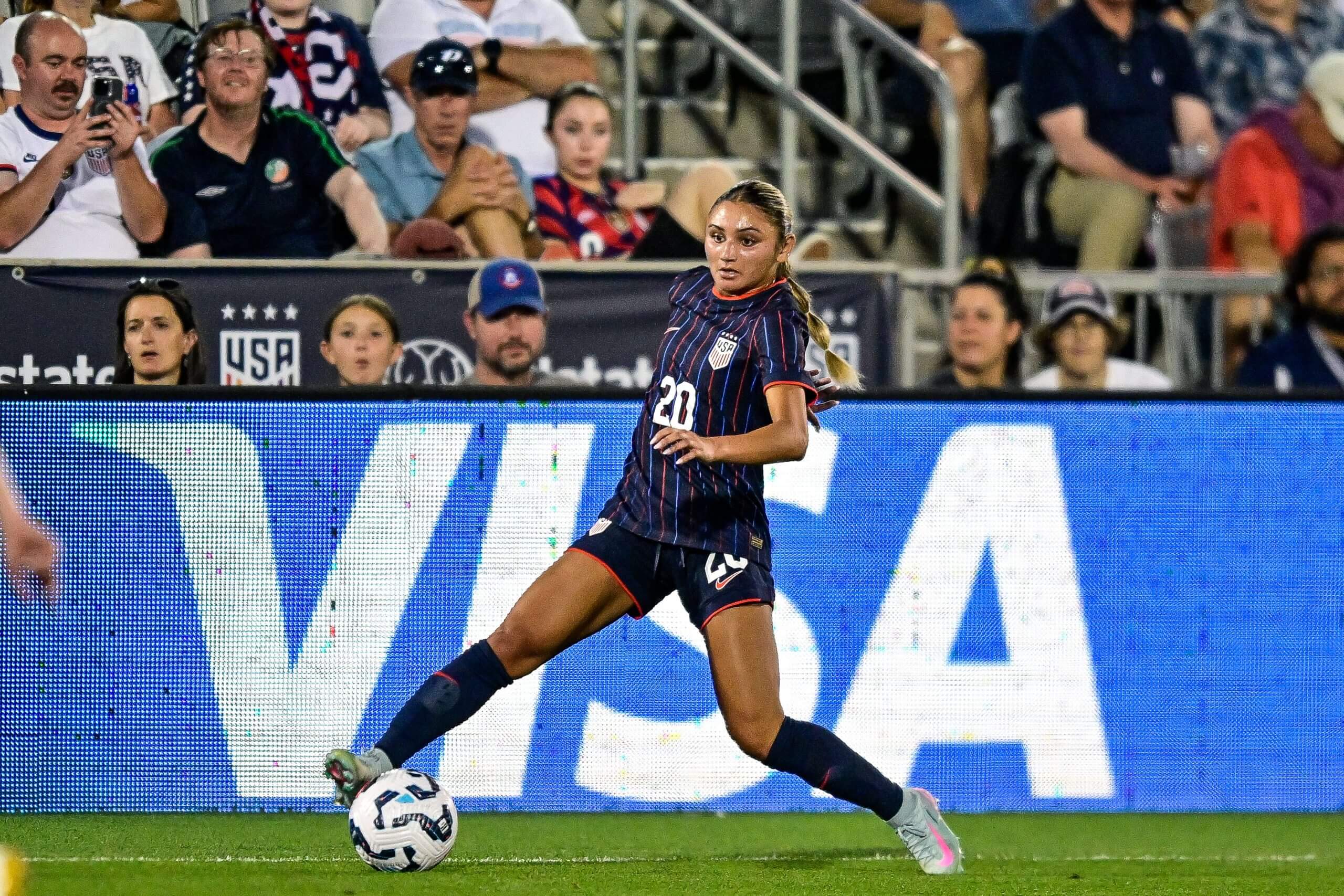 Giselle Thompson patea el balón en el campo.