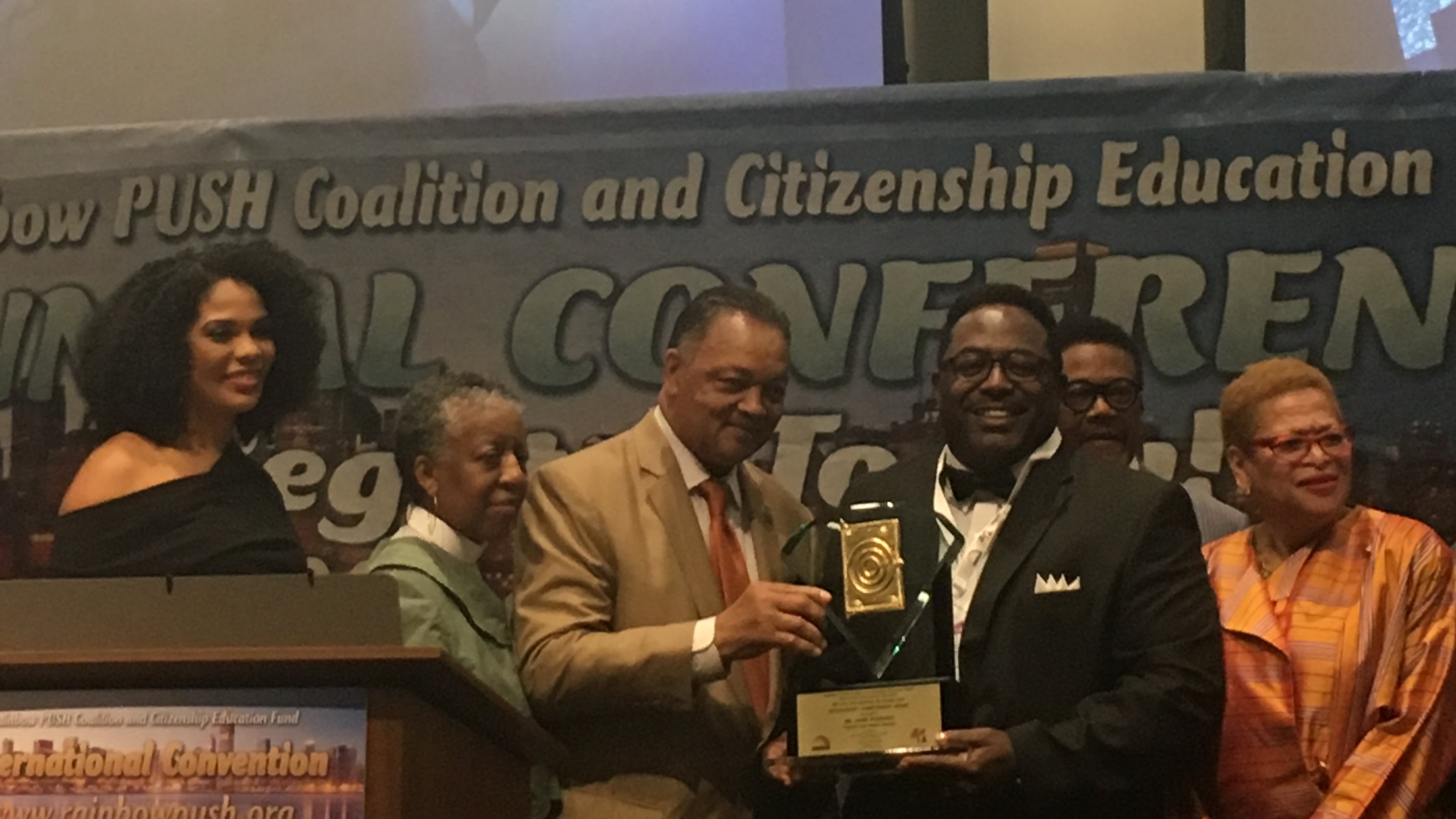 Jamie Pleasant (centro derecha), fundador y pastor principal de New Zion Christian Church en Suwannee, en 2019 con el Rev. Recibe un premio de manos de Jesse Jackson. (Cortesía de Rainbow Push Coalition)