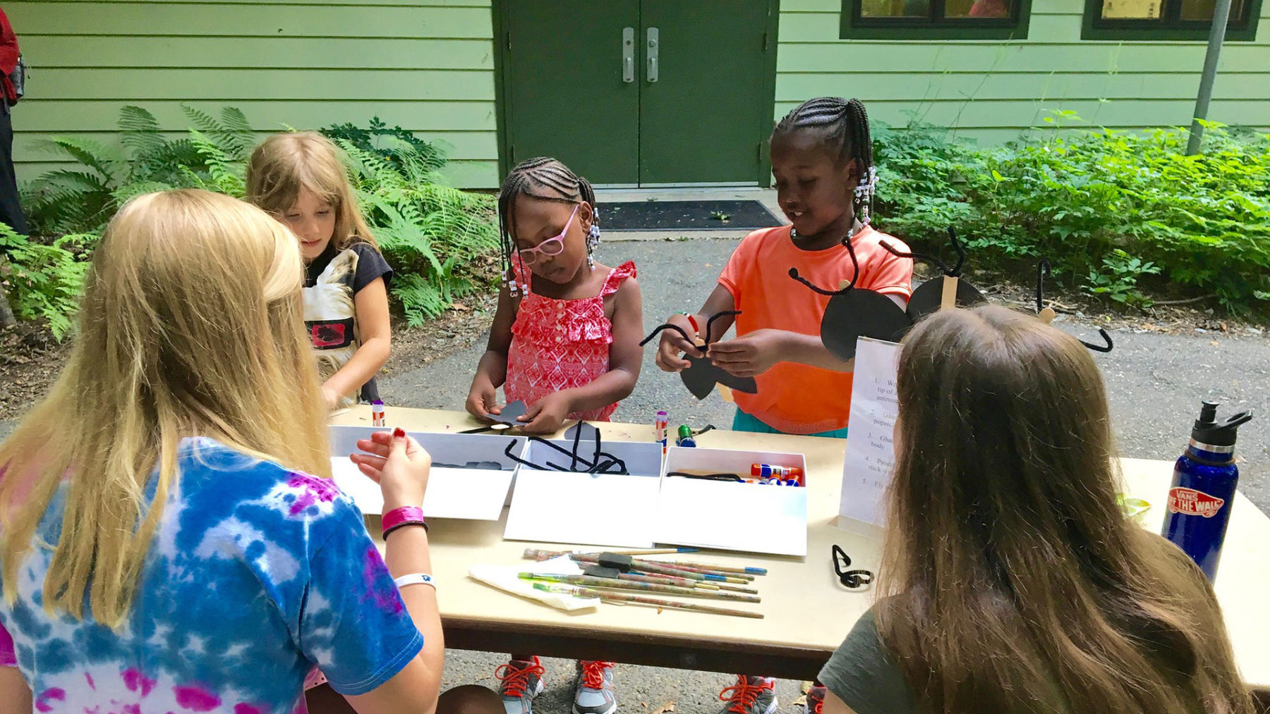 Los niños juegan y crean una obra de arte en Brookside Nature Center