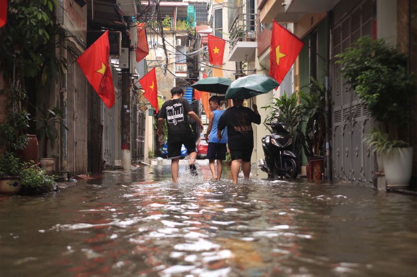 La gente camina por una calle inundada causada por el tifón Kajiki, en Hanoi, Vietnam, el martes 26 de agosto de 2025.